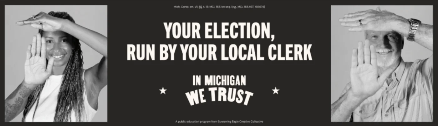 In Michigan We Trust billboard reading &ldquo;Your election, run by your local clerk,&rdquo; with two Michiganders holding up the Michigan mitten hand sign
